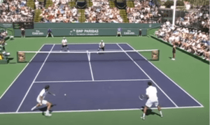 Four players on a tennis court with two at the baseline and two at the net